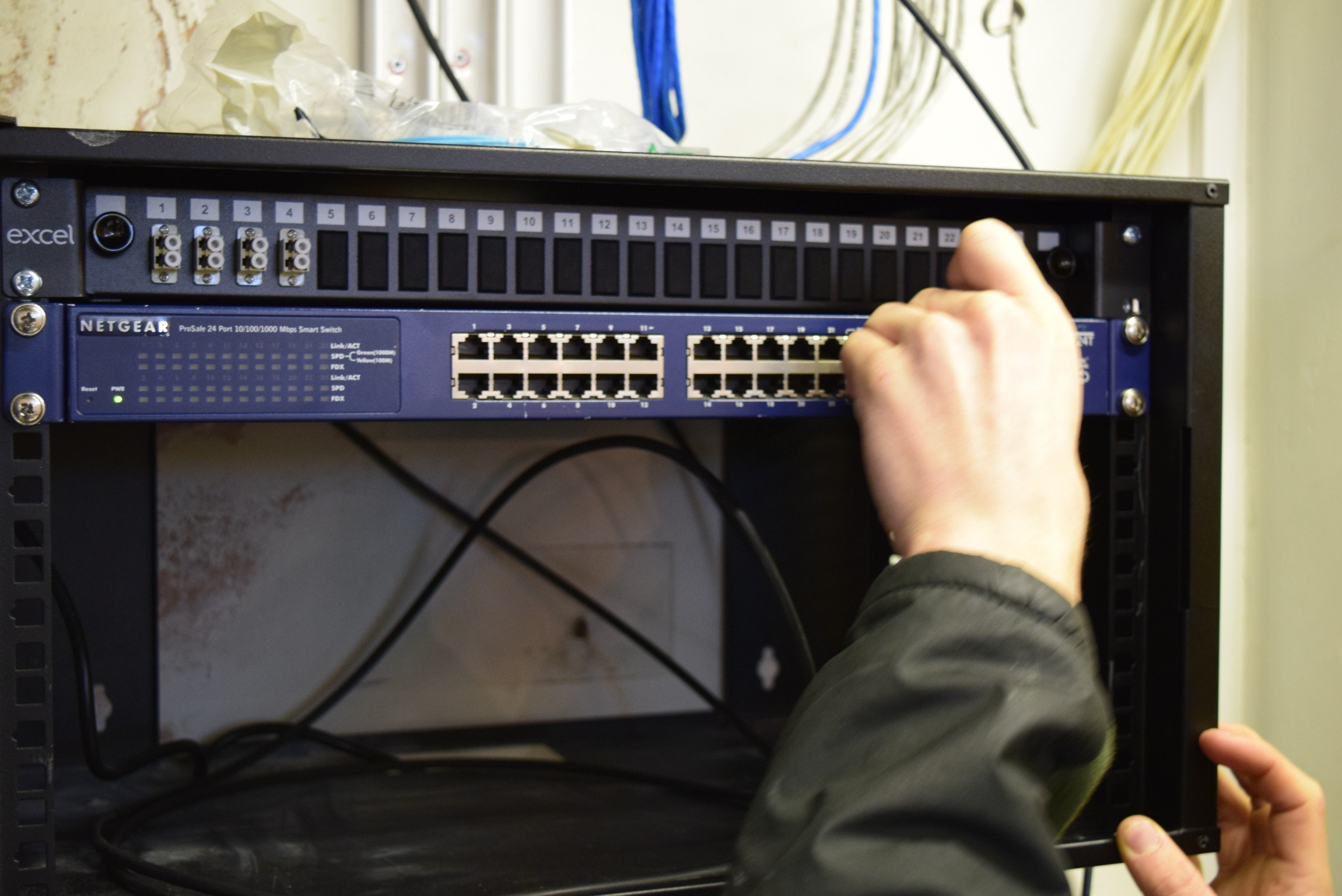 Engineer installing a gigabit data switch, demonstrating expertise and precision in setting up high-speed and efficient data networking equipment.
