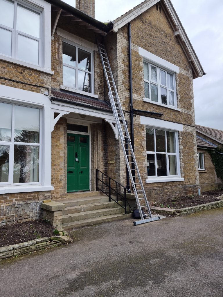 Installation team using extended ladders at a nursing home for 4G broadband, ensuring enhanced connectivity for residents and staff
