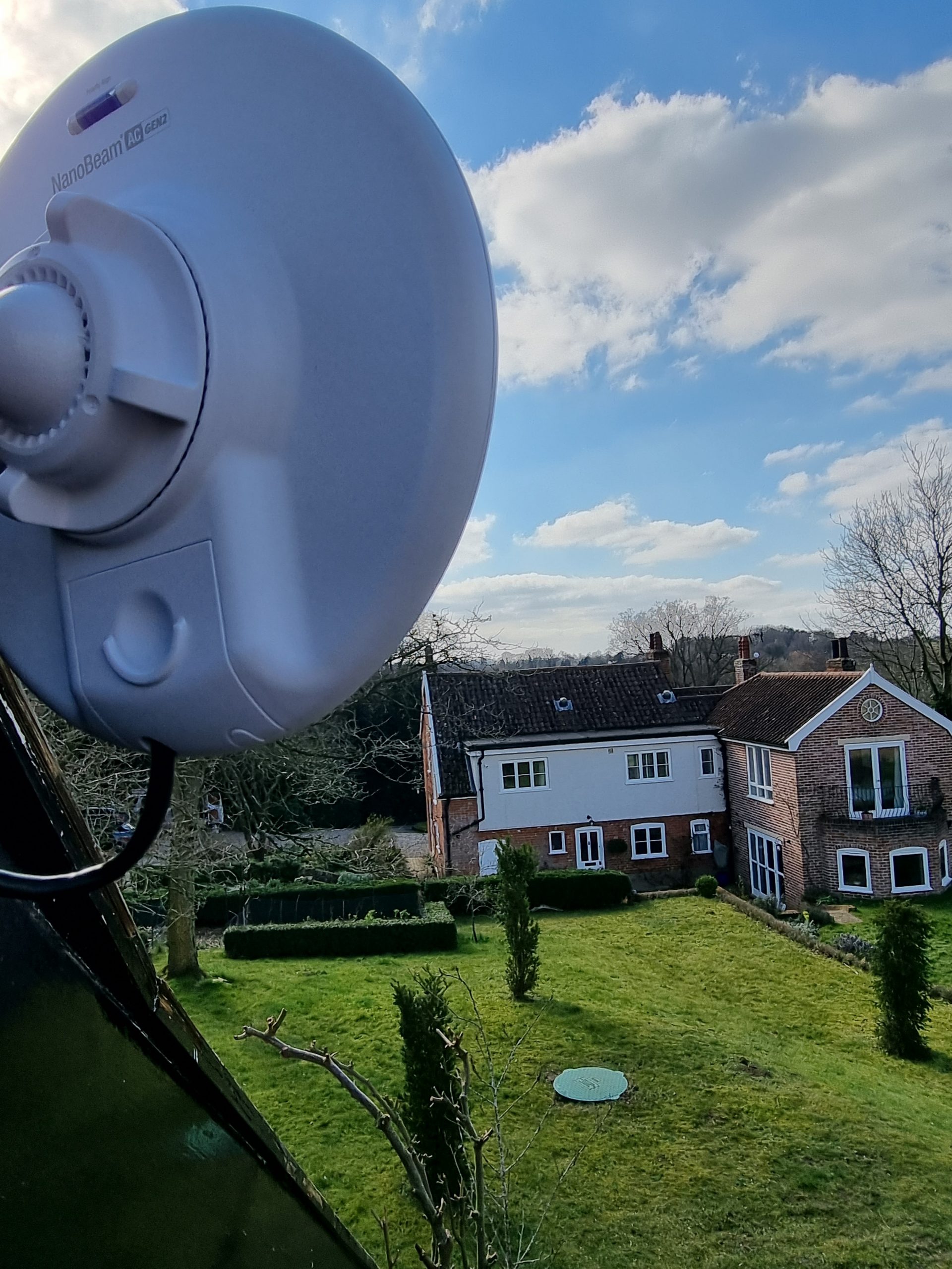 Installation of point-to-point WiFi link connecting to a house under clear blue skies, ensuring efficient connectivity and seamless integration.